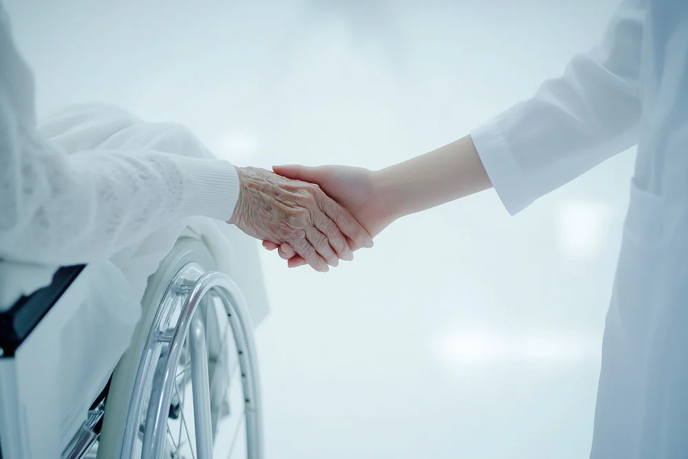 강남세브란스병원 근처 암요양병원|휠체어에 앉은 노인 환자의 손을 맞잡은 의사